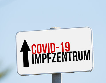 Schild mit Covid-19 Impfzentrum
