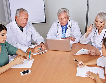 Praxisteam an einem Tisch bei einem Meeting