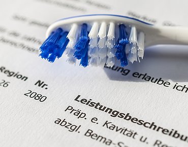 Zahnbürste liegt auf einer Rechnung