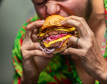 Junger Mann isst einen Burger