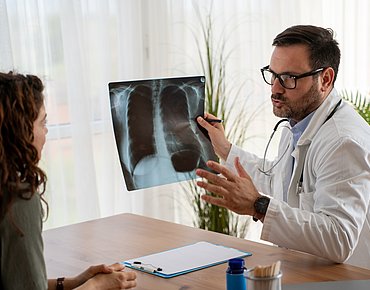 Arzt zeigt Patientin Röntgen Arzt zeigt Patientin Röntgen
