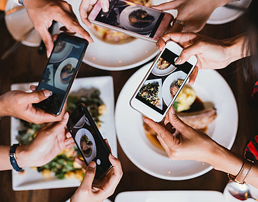 Restaurant Besucher schießen Fotos von ihren bestellten Gerichten