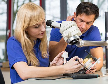 Zwei Menschen arbeiten an einem Inlay