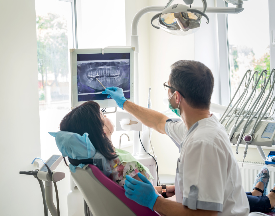Zahnarzt zeigt Patientin Roentgenbild