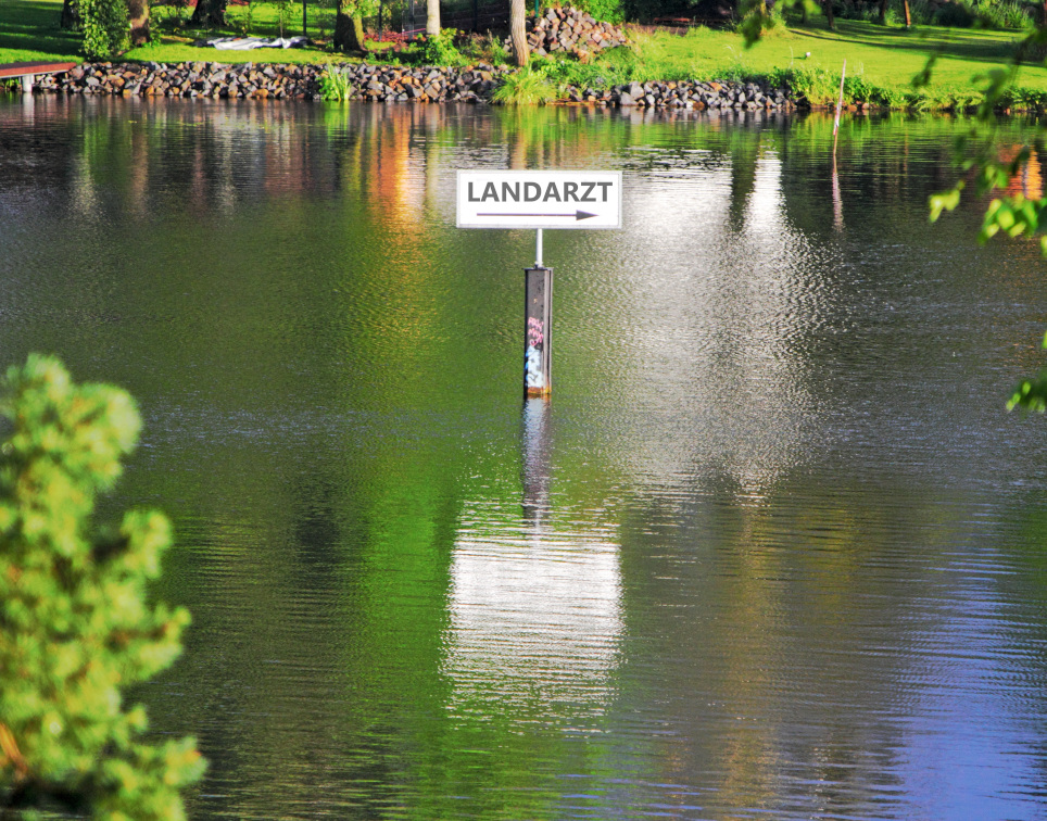 Schild "Landarzt" im Hochwasser